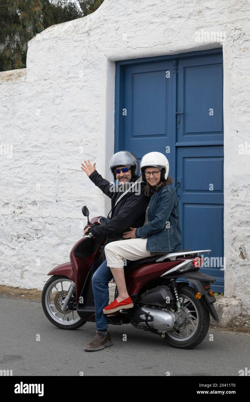 Una coppia matura posa sulla propria moto in Grecia; Mykonos, Egeo meridionale, Grecia Foto Stock