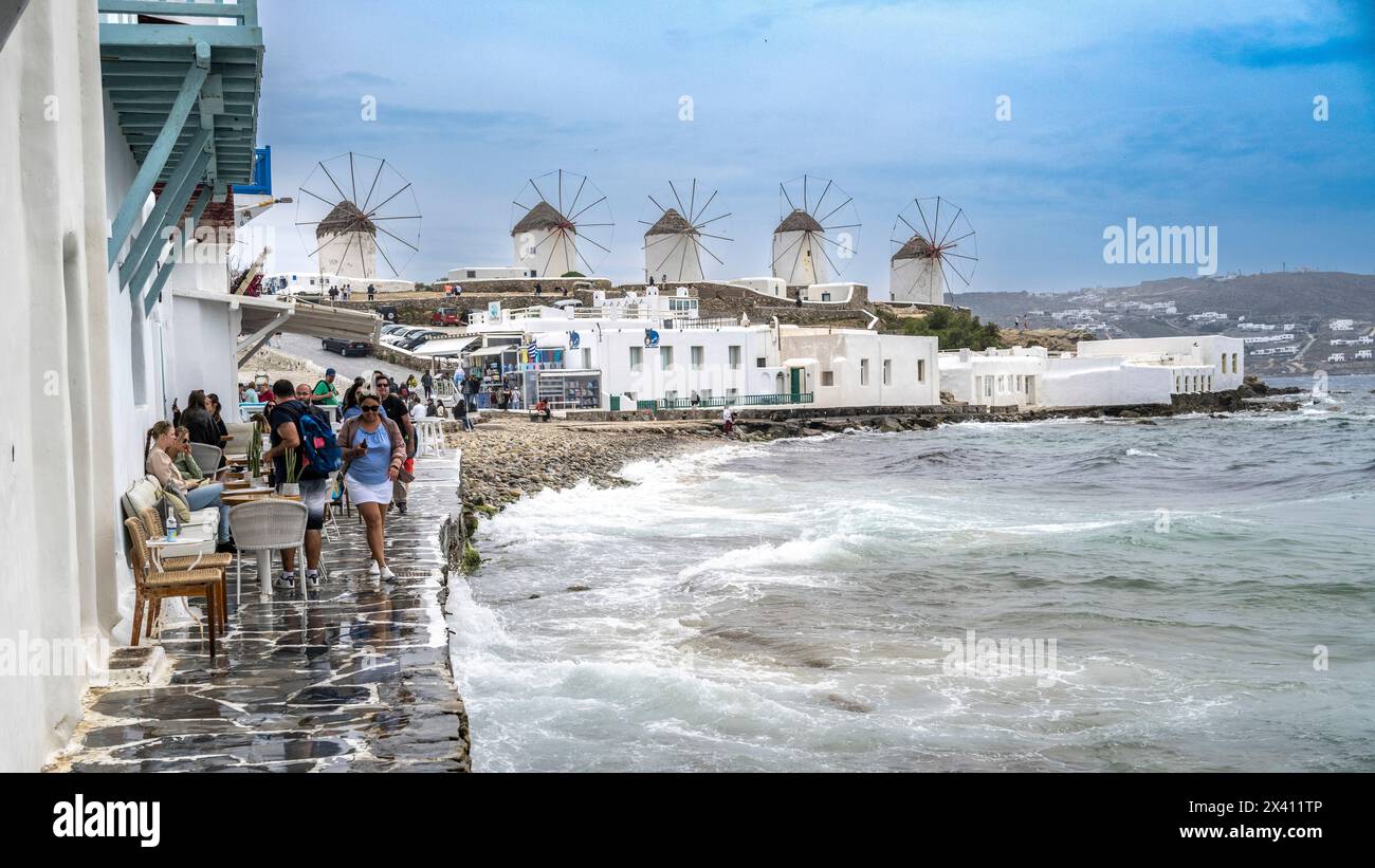 Iconici mulini a vento ed edifici bianchi a Mykonos, con vista sul Mar Egeo e sulla costa; Mykonos, Egeo meridionale, Grecia Foto Stock