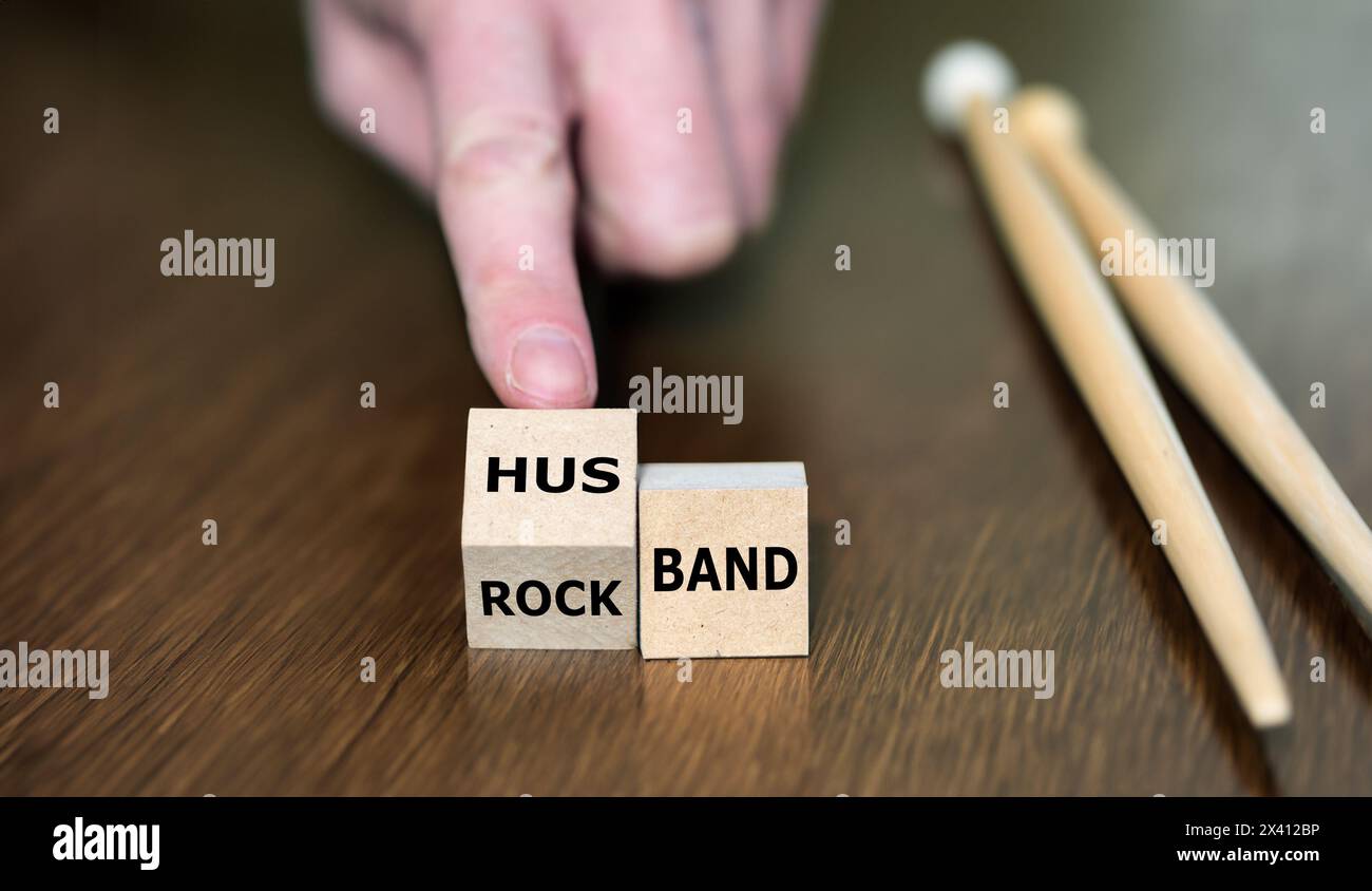 Simbolo per sposarsi e smettere di far parte di una rock band. La mano gira il cubo e cambia l'espressione rock band in marito. Foto Stock