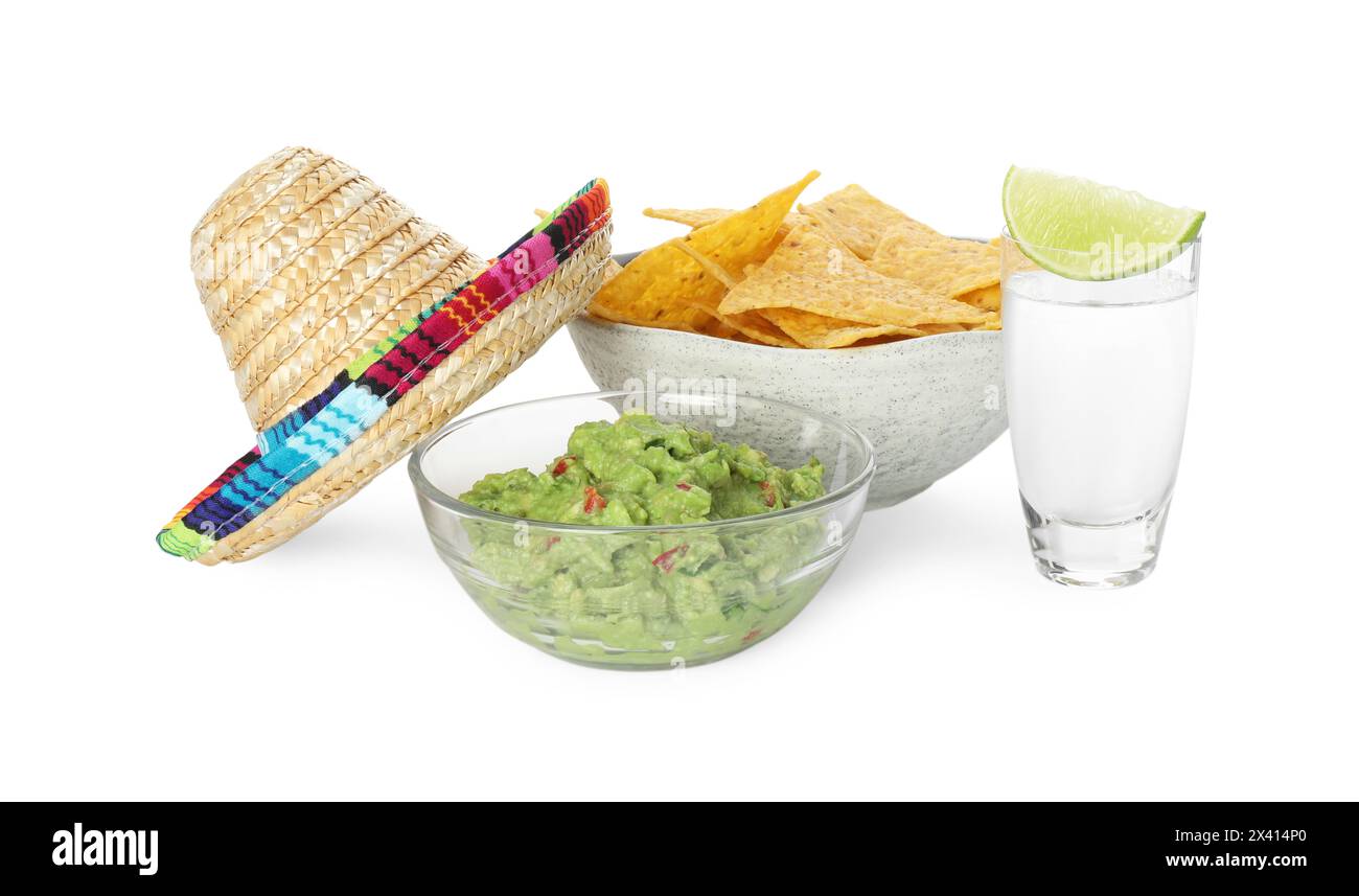Cappello sombrero messicano, tequila con lime, patatine di nachos e guacamole in ciotole isolate su bianco Foto Stock