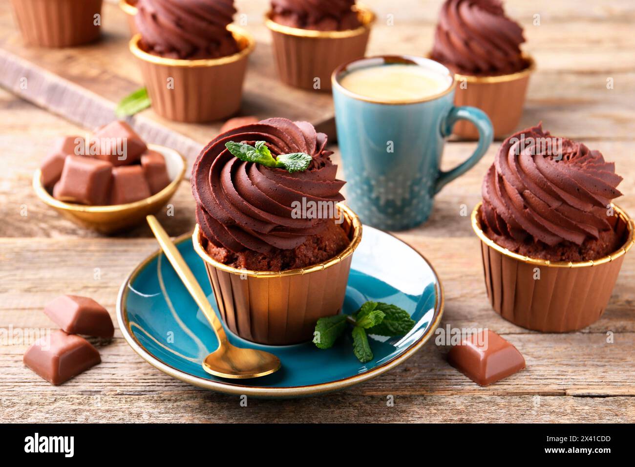 Deliziosi cupcake con pezzi di menta e cioccolato su un tavolo di legno Foto Stock