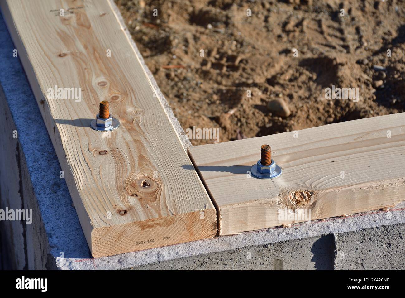 Soglia su ancoraggi di fondazione in calcestruzzo. Tassello filettato per fissare il pannello di legno. Foto Stock