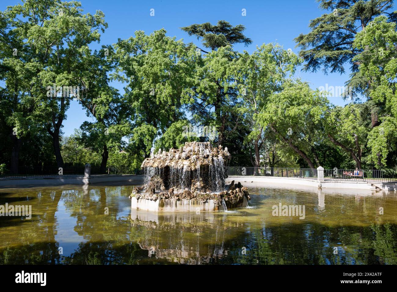 Madrid, Spagna - 13 aprile 2024 - Fontana nel bacino delle campane, Estanque de Campanillas, nel Parco del Retiro a Madrid, Spagna, nelle limpide mattine di primavera. Foto Stock