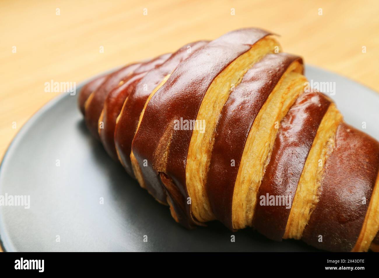 Primo piano di un croissant al cioccolato bicolore servito su un piatto nero Foto Stock