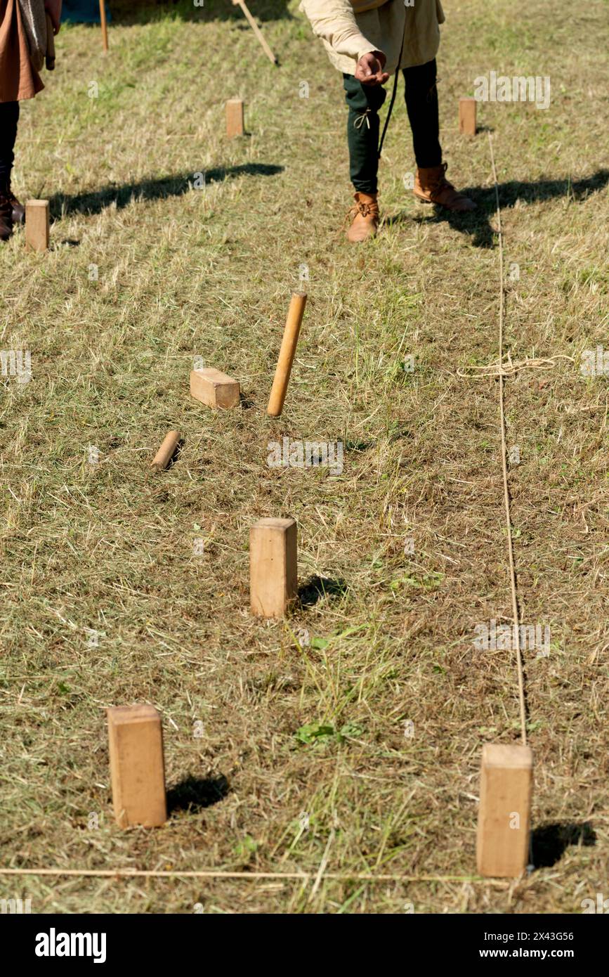 Italia. Lombardia, Reenactment Mediaeval, l'uomo gioca un gioco vichingo svedese chiamato Kubb Foto Stock