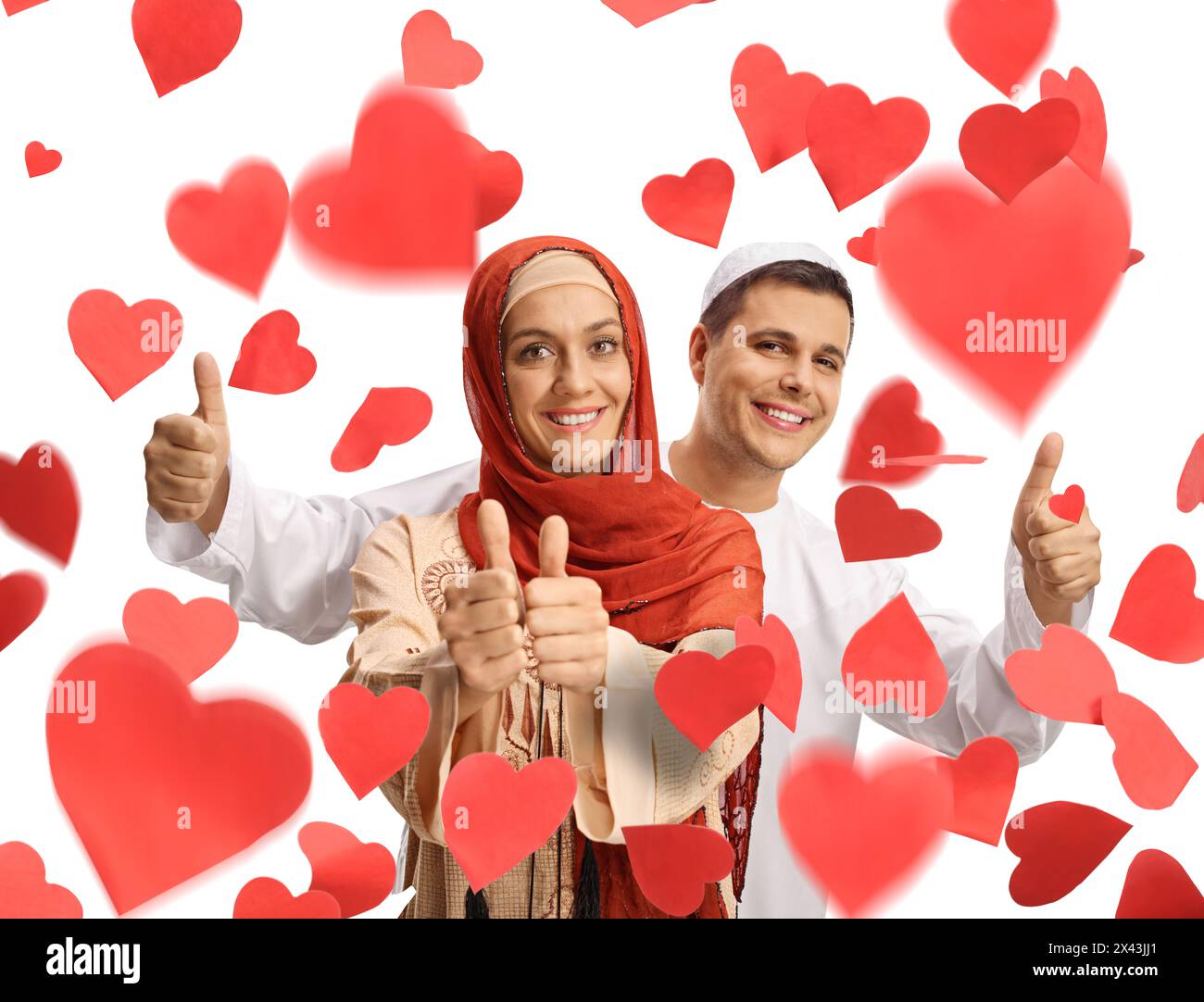 Giovane uomo e donna in abiti etnici che mostrano i pollici sotto i cuori rossi isolati su sfondo bianco Foto Stock