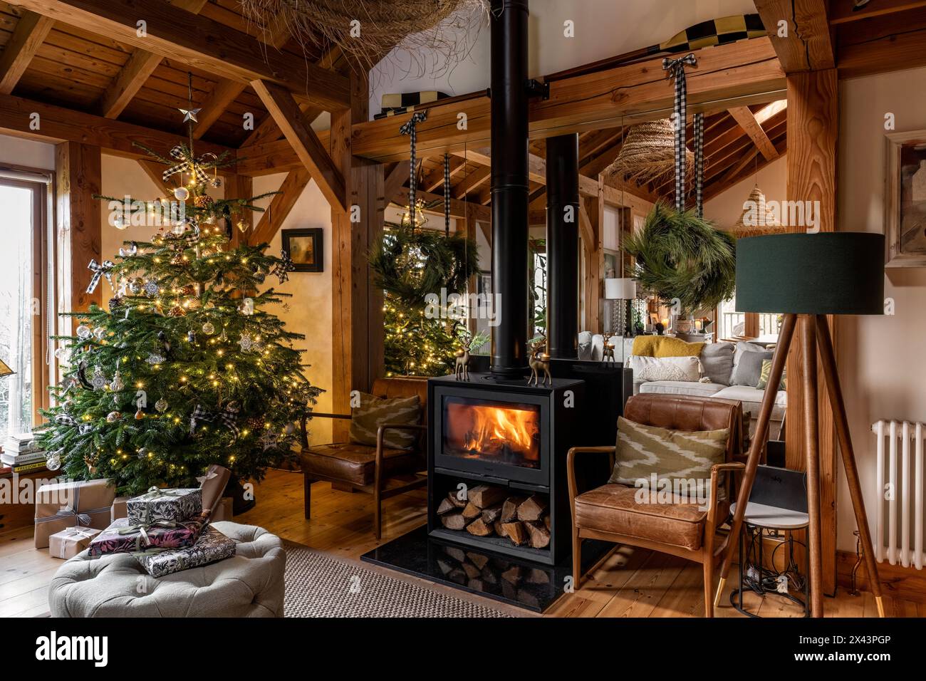 Stufa a legna e albero di Natale nella casa dell'East Sussex, Inghilterra sud-orientale, Regno Unito Foto Stock