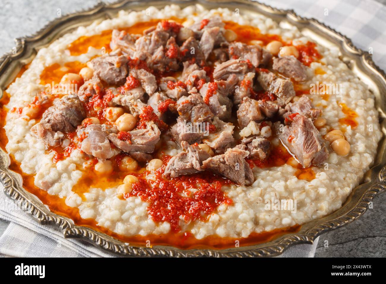 Keskek o kashkak cibo tradizionale turco, a base di carne e grano, delizioso cibo ramadan primo piano sul piatto sul tavolo. Orizzontale Foto Stock