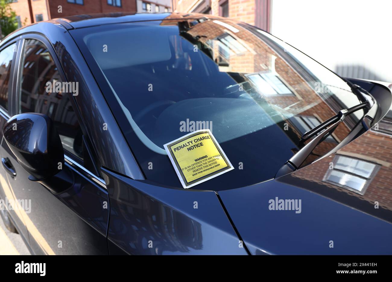 Loughborough, Leicestershire, Regno Unito. 30 aprile 2024. Un avviso di penalità di addebito bloccato sul parabrezza di un'auto parcheggiata su due linee gialle. Foto Stock
