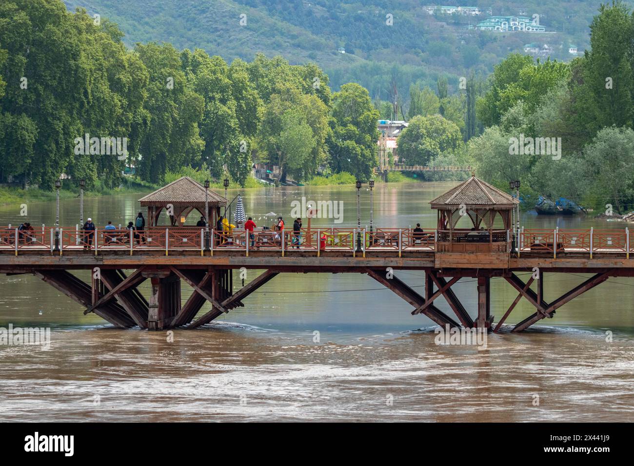 La gente si vede camminare su un ponte mentre il livello dell'acqua nel fiume Jhelum attraversava il segno della "dichiarazione di inondazione" a Srinagar il martedì mattina. Il tempo dovrebbe migliorare da domani a Jammu e Kashmir, con il dipartimento meteorologico locale che prevede condizioni generalmente nuvolose fino al 5 maggio. Foto Stock