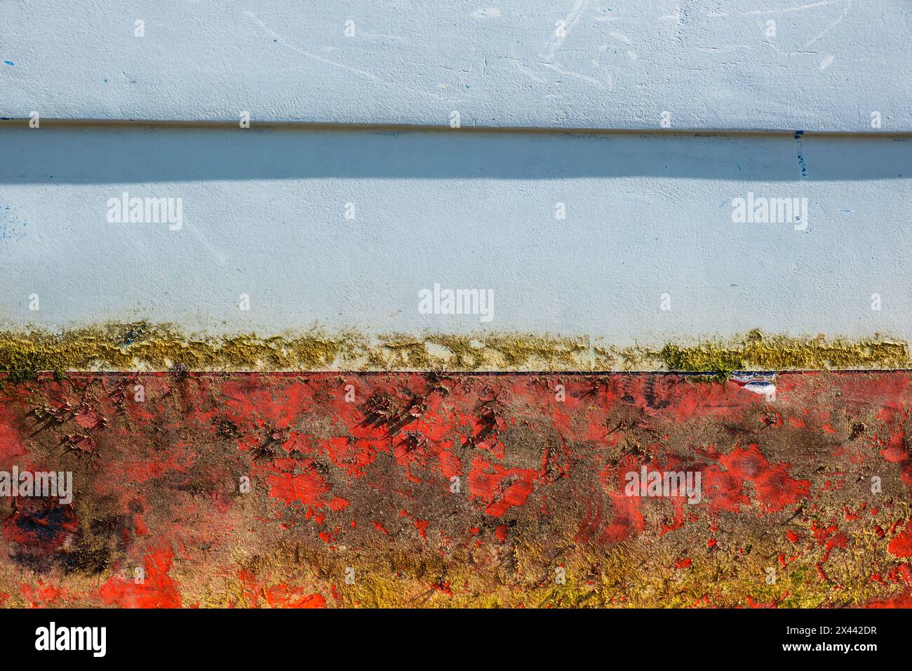 Una vista ravvicinata della vernice sul lato dello scafo di un peschereccio a Newquay, in Cornovaglia, nel Regno Unito. Foto Stock