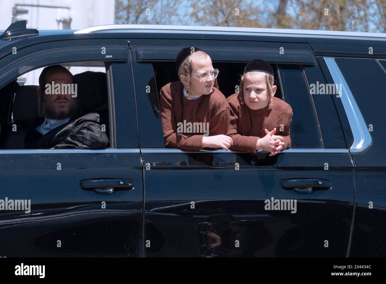 I fratelli ebrei ortodossi e il loro padre osservano i compagni ebrei chassidici Satmar che si divertono a Pesach facendo un giro in elicottero. A Kiryas Joel Foto Stock