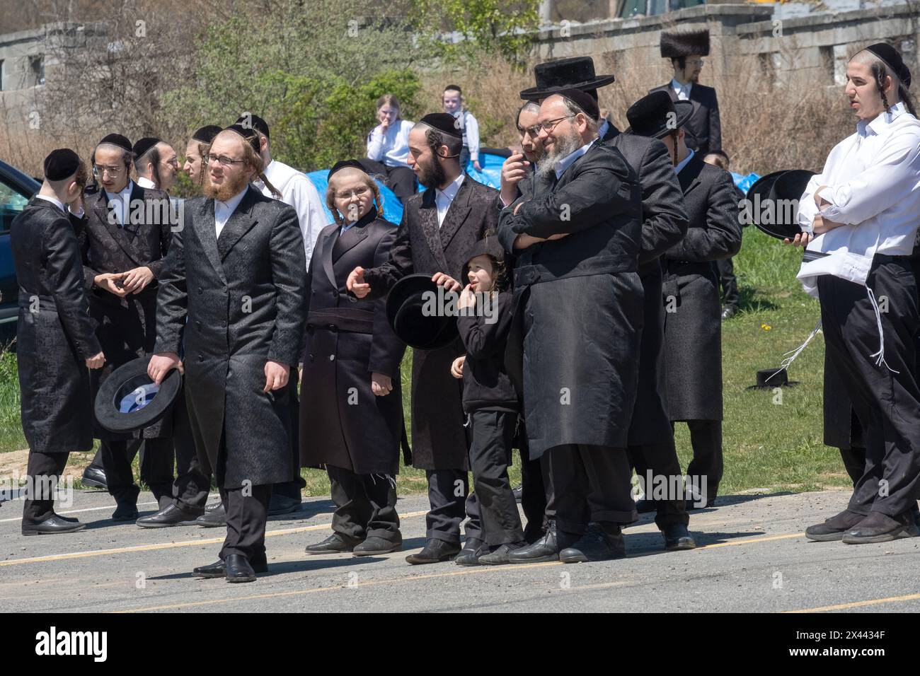 A Pesach, quando è obbligatorio divertirsi, un gruppo di uomini Satmar aspetta di fare un giro in elicottero. A Kiryas Joel nella contea di Orange, New York. Foto Stock