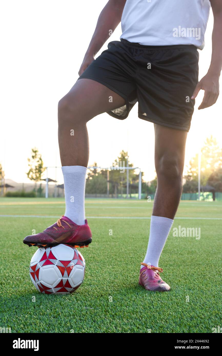 Ritratto del giocatore di calcio sul campo con il piede sulla palla. Giocatore di calcio maschile con il piede sulla palla sull'erba Foto Stock