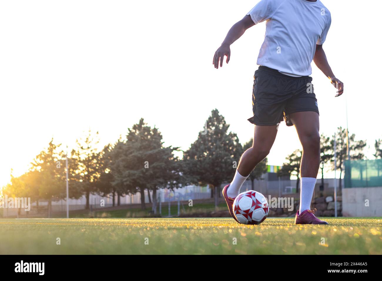 Giocatore di football sul campo che corre con la palla. Primo piano dei piedi del giocatore che corrono con la palla sul campo. I piedi del giocatore con la palla che segna un Foto Stock