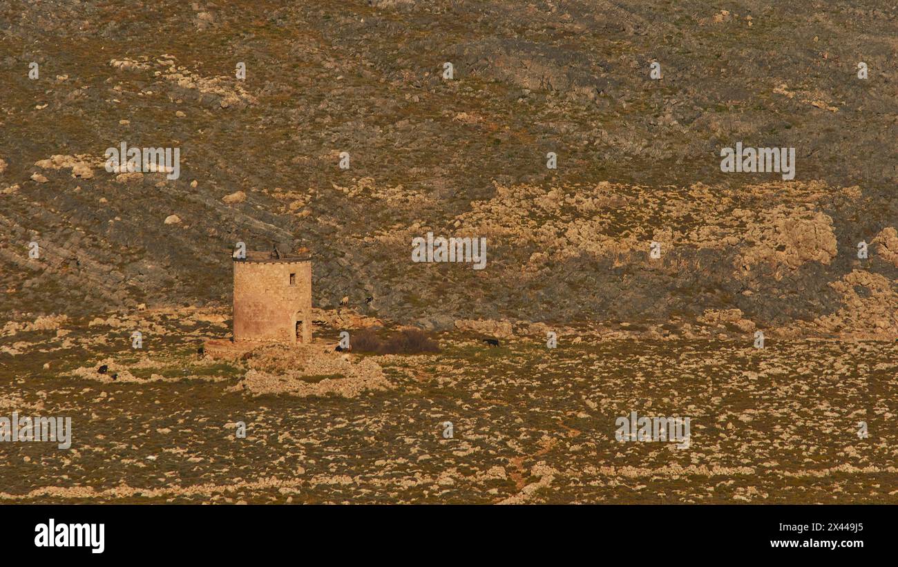 Vecchio mulino a vento in pietra in un paesaggio roccioso erboso, Lindo, Rodi, Dodecaneso, isole greche, Grecia Foto Stock