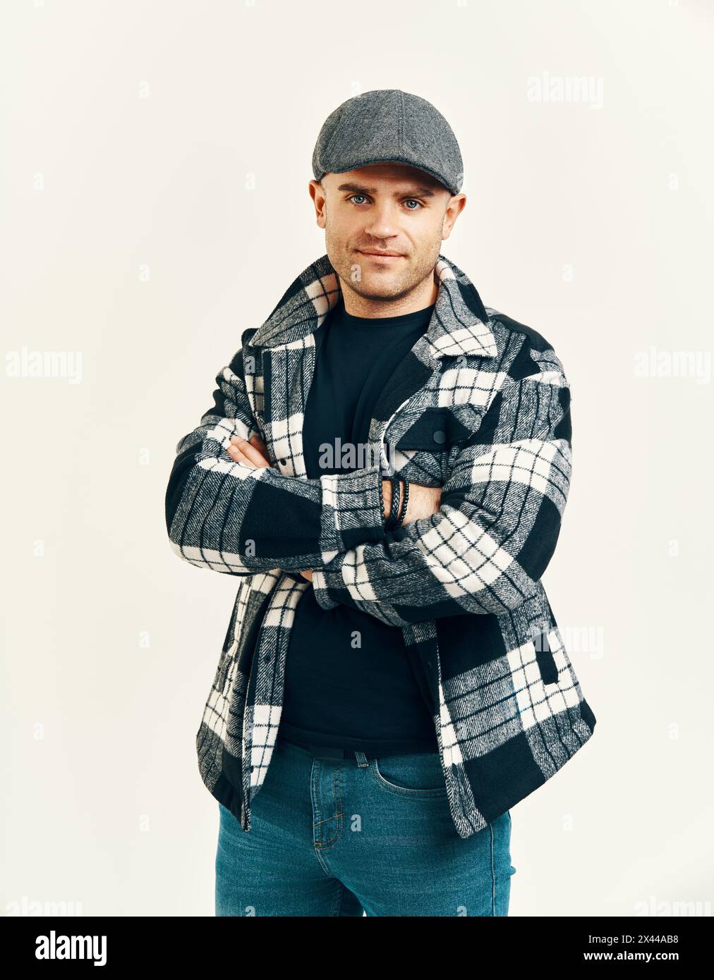 Uomo alla moda con cappello in tweed su morbido sfondo bianco. Ispirazione in stile Peaky Blinders Foto Stock