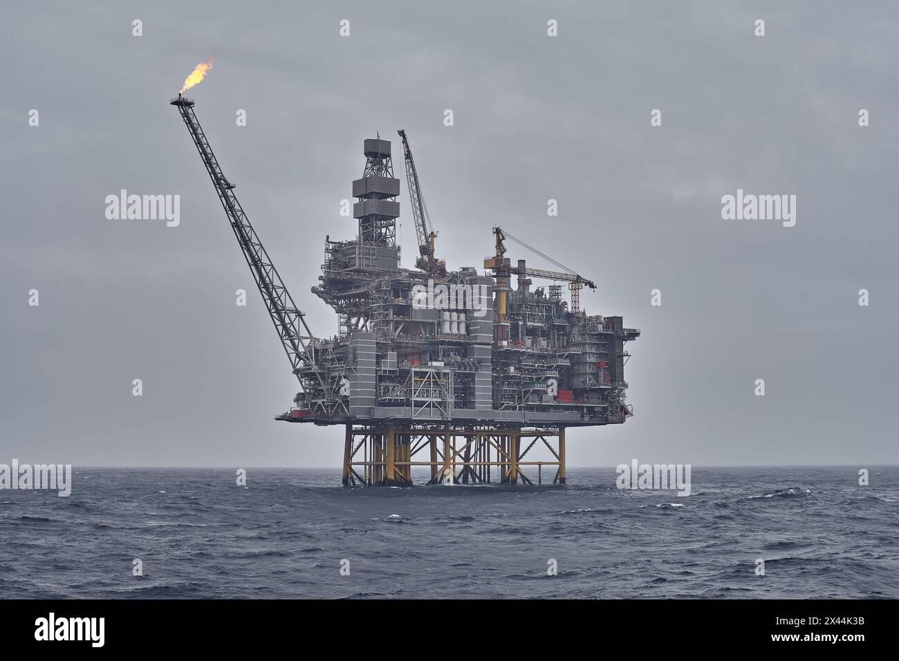 Vista panoramica del carro di perforazione offshore con jackup all'orizzonte in una giornata grigia nuvolosa in mare. Foto Stock