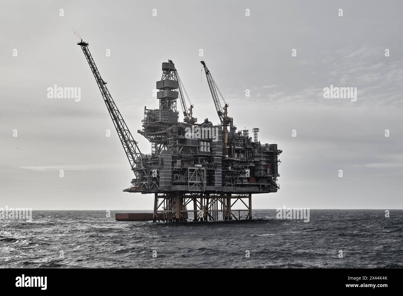 Primo piano della piattaforma offshore per petrolio e gas con una nave di rifornimento che effettua operazioni di carico in mare. Foto Stock