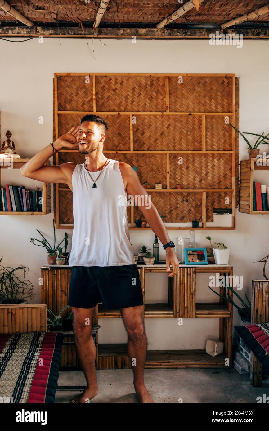 Tutta la lunghezza di un uomo sorridente che balla mentre è in piedi al resort Foto Stock