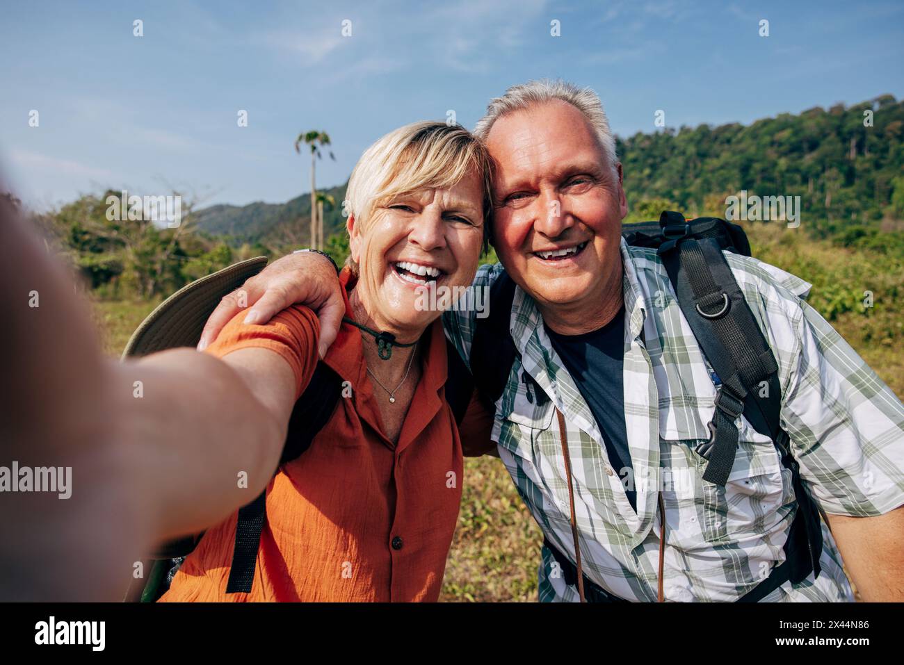 Ritratto di una donna anziana sorridente che scatta selfie con un uomo in vacanza Foto Stock