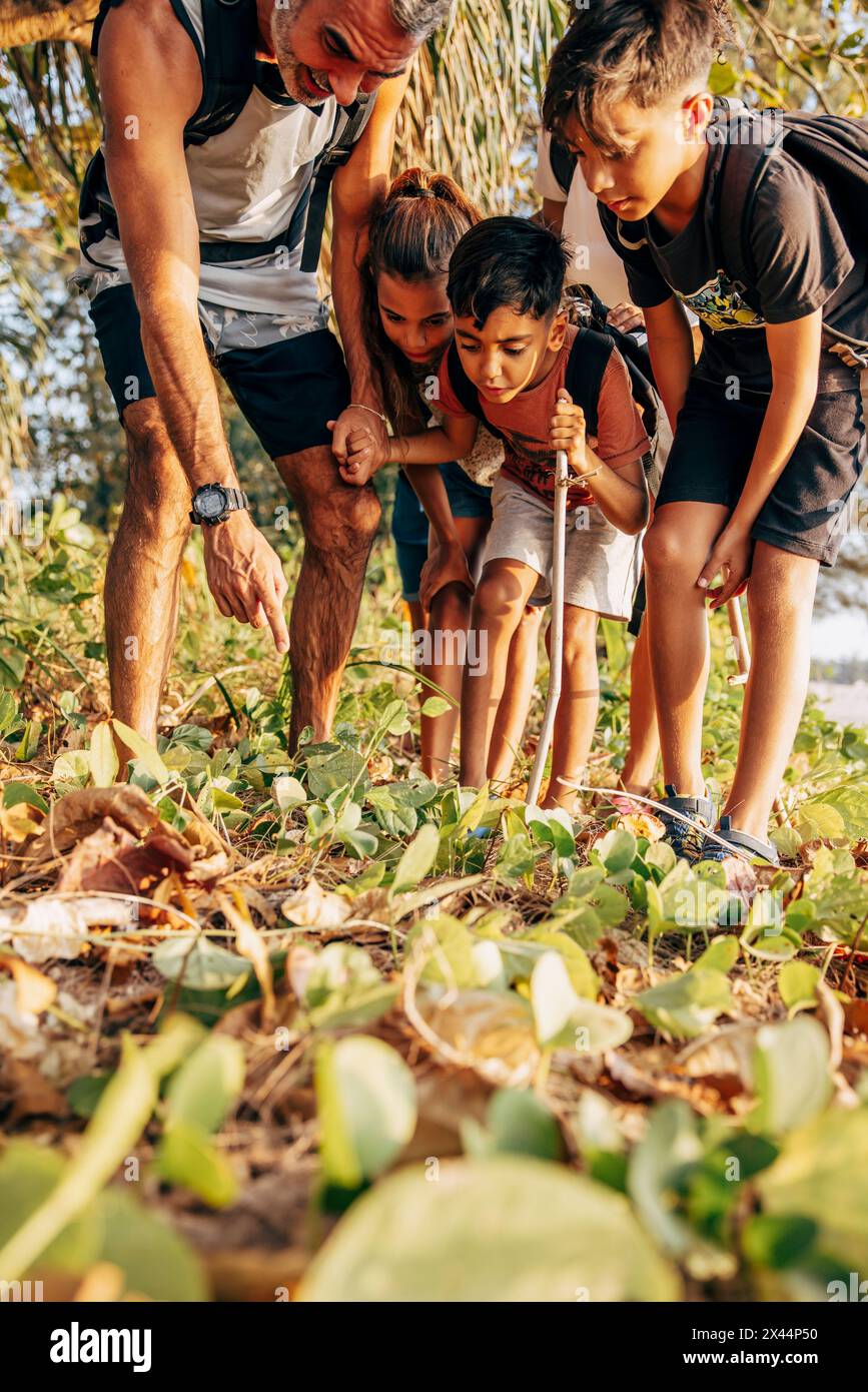 Padre che esplora la foresta con i bambini in vacanza Foto Stock