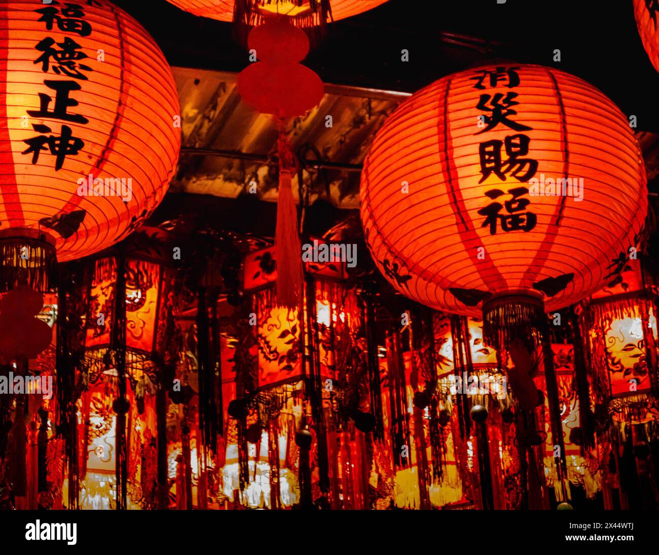Una serie di lanterne a sospensione sono installate sul soffitto di un tempio locale per la cerimonia di compleanno del Signore della Terra. Foto Stock