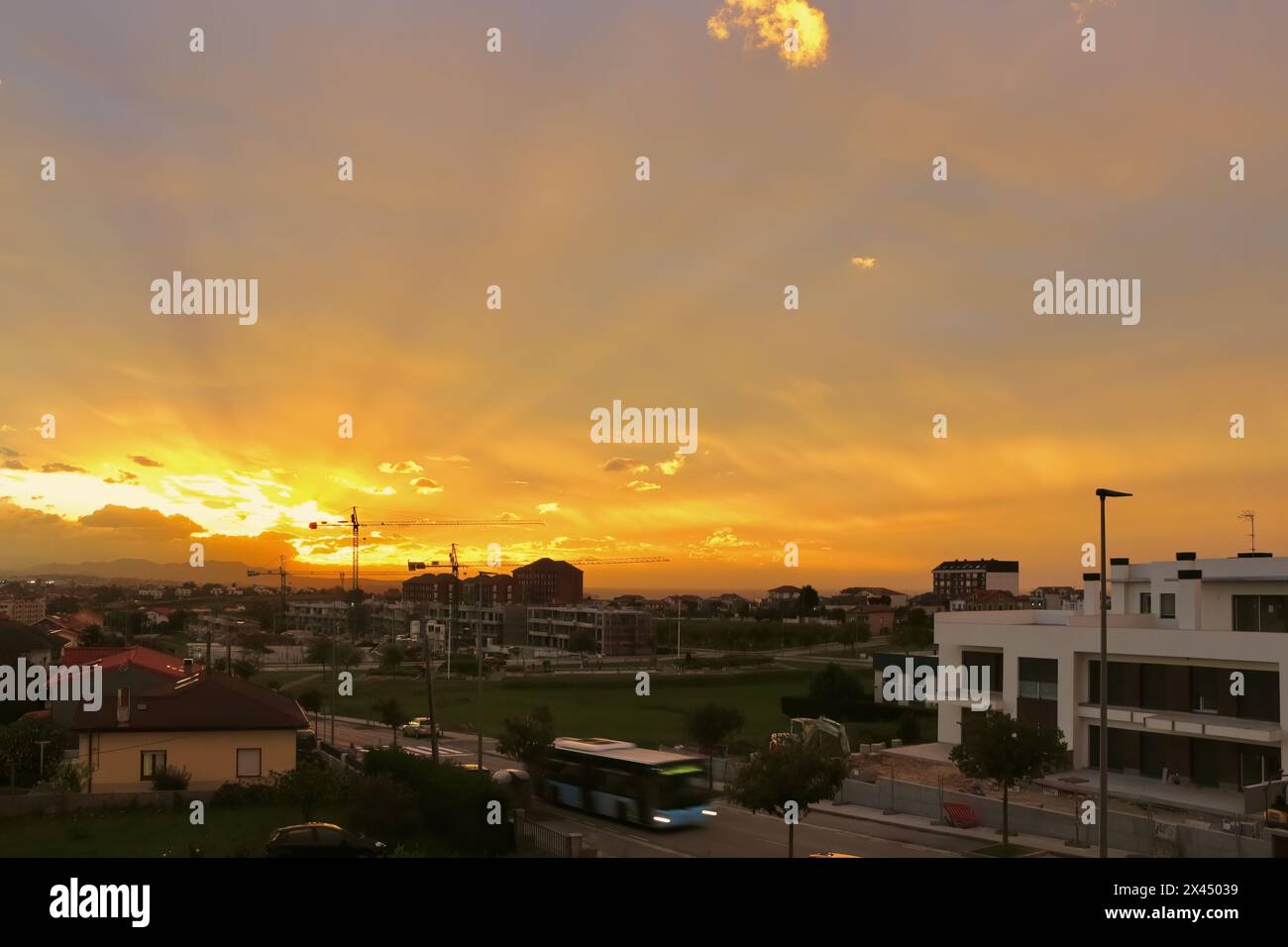 Forte luce solare al crepuscolo sotto la copertura di nuvole pesanti con raggi solari che si irradiano sui sobborghi della città di Santander, Cantabria, Spagna Foto Stock