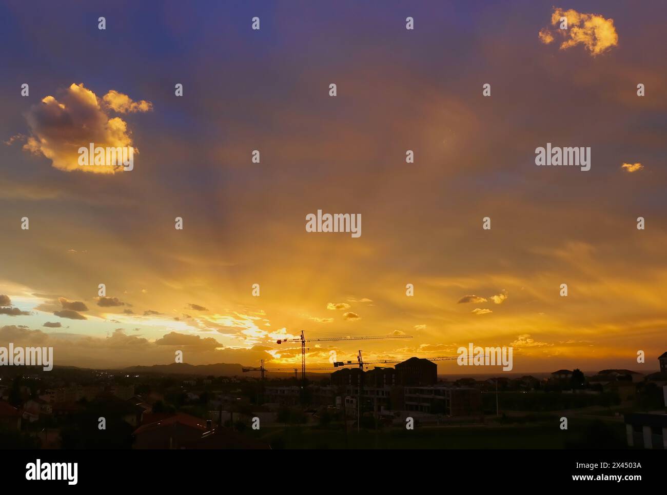 Forte luce solare al crepuscolo sotto la copertura di nuvole pesanti con raggi solari che si irradiano sui sobborghi della città di Santander, Cantabria, Spagna Foto Stock