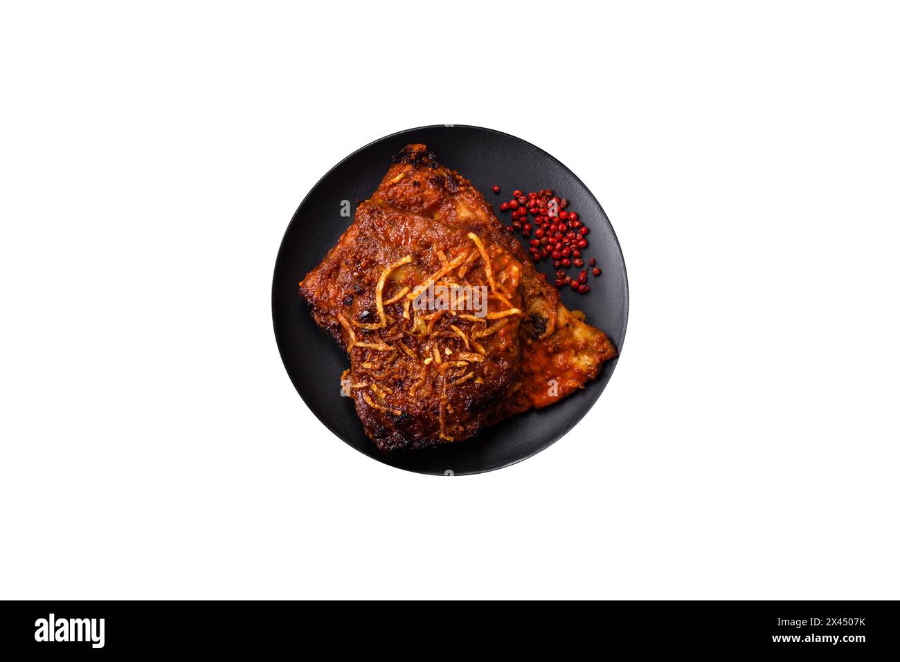 Deliziose costolette di maiale o di manzo cotte alla griglia con sale, spezie ed erbe aromatiche su fondo di cemento scuro Foto Stock