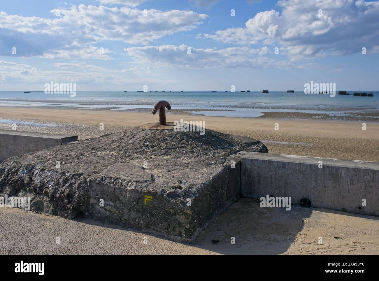 Asnelles, Francia - 29 aprile 2024: Quello che rimane del porto artificiale di Arromanches (Mulberry B) durante la seconda guerra mondiale. Ancora di ormeggio. Whale e Phoenix CA Foto Stock
