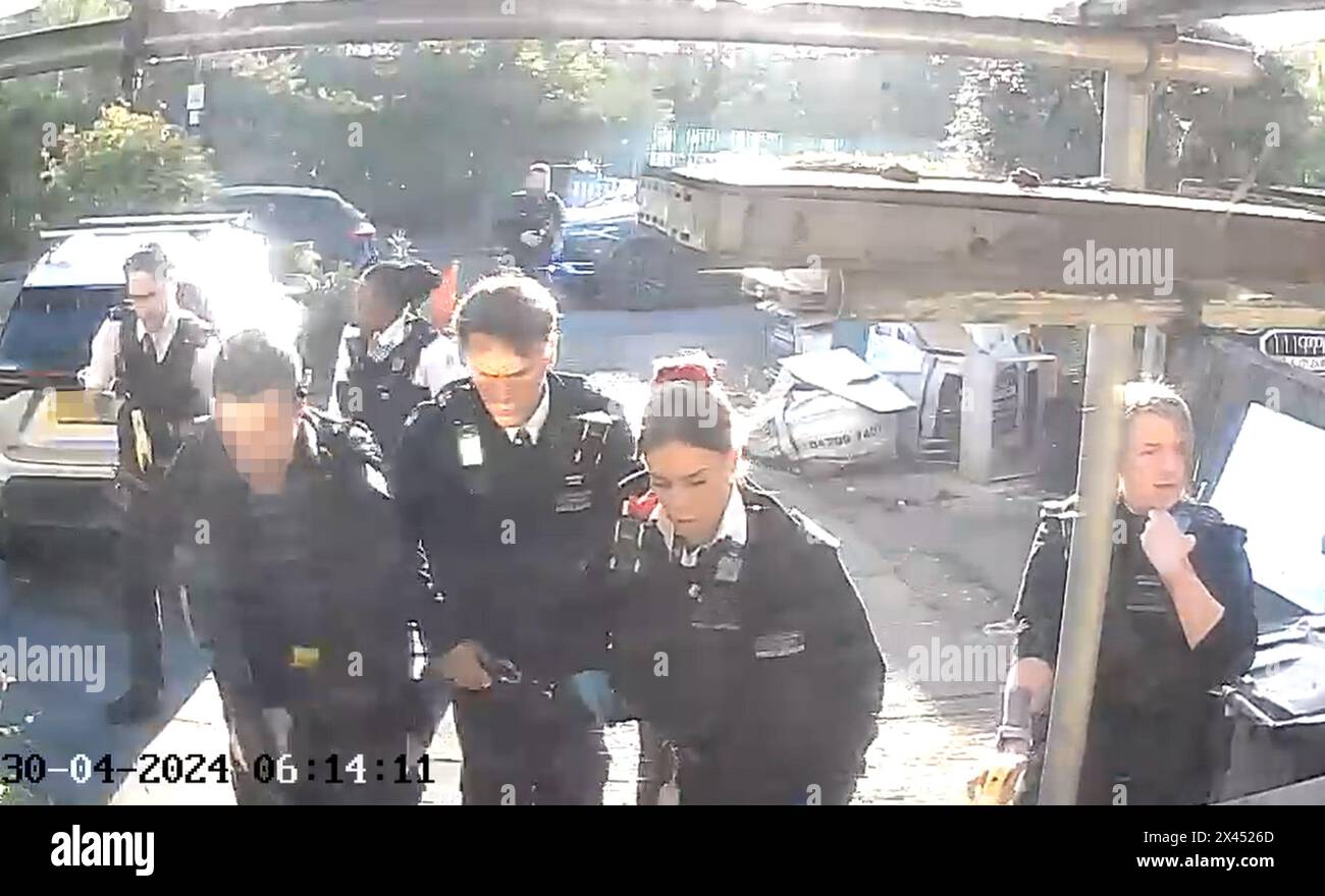 TARGA E VOLTI DI AGENTI DI POLIZIA ARMATI PIXELLATI DAL BANCO DELLE FOTO della PA riprendere da una telecamera campanaria di agenti di polizia dopo aver effettuato il tasking e detenuto un uomo che brandisce la spada a Hainault, nord-est di Londra, dopo che un ragazzo di 14 anni è morto dopo essere stato pugnalato a seguito di un attacco a membri del pubblico e a due agenti di polizia. Data foto: Martedì 30 aprile 2024. Foto Stock