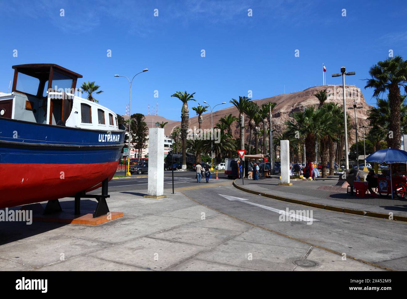 Barca da pesca su Av Maximo Lira accanto all'ingresso/uscita dal porto, promontorio di El Morro sullo sfondo, Arica, Cile Foto Stock