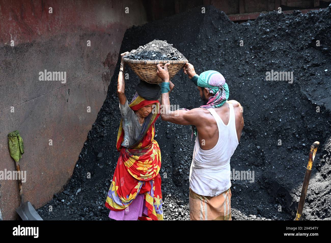 Dacca, Bangladesh, il 30 aprile 2024. I lavoratori scaricano carbone da una nave cargo oltre il fiume Turag durante un'ondata di caldo a Dacca, Bangladesh, il 30 aprile 2024. Foto Stock