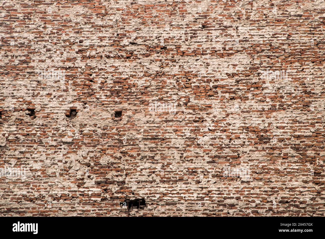 Il muro di mattoni del vecchio edificio si chiude come sfondo grunge Foto Stock
