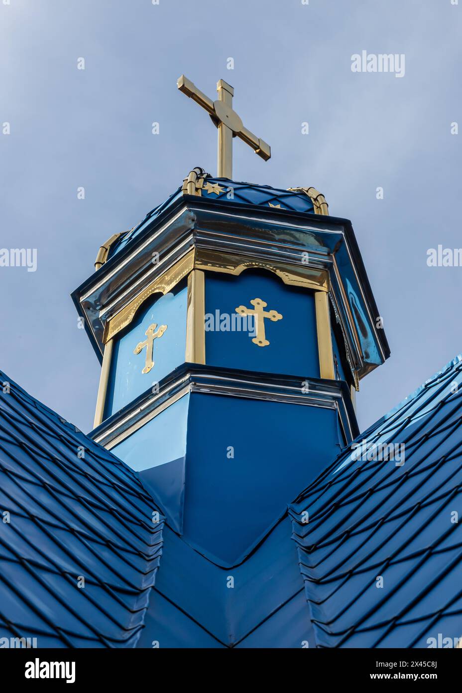 Primo piano di una Croce su una chiesa cristiana su sfondo blu. Foto Stock