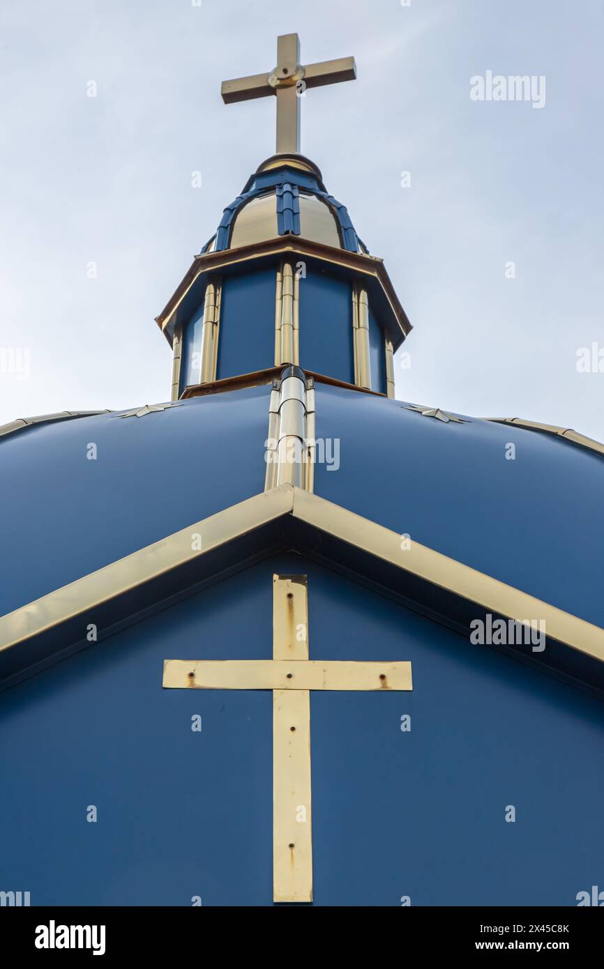 Primo piano di una Croce su una chiesa cristiana su sfondo blu. Foto Stock