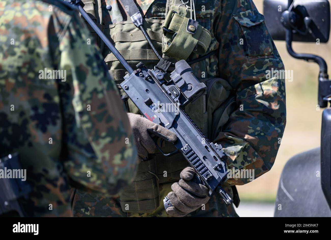 30 aprile 2024, Sassonia, Weißkeißel: Un soldato della Bundeswehr detiene una mitragliatrice MP7 durante l'esercitazione "National Guardian 2024" come parte della serie "Quadriga" di esercitazioni della Bundeswehr presso l'area di addestramento militare di Oberlausitz. Durante l'esercitazione della Bundeswehr "National Guardian", le forze di sicurezza nazionale in tutta la Germania stanno esercitando la loro missione principale di proteggere e proteggere le infrastrutture che sono vitali per la difesa del paese. I membri del servizio di riserva della Homeland Security Company della Sassonia, della Sassonia-Anhalt e della Turingia prendono parte all'esercizio odierno. Foto: Robert Michael/ Foto Stock