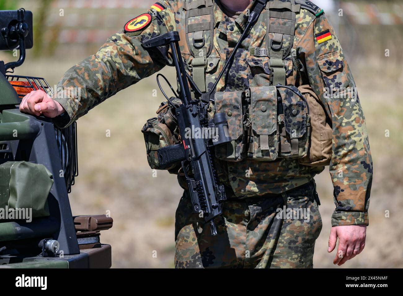30 aprile 2024, Sassonia, Weißkeißel: Un soldato della Bundeswehr trasporta una mitragliatrice MP7 durante l'esercitazione "National Guardian 2024" come parte della serie "Quadriga" di esercitazioni della Bundeswehr presso l'area di addestramento militare di Oberlausitz. Durante l'esercitazione della Bundeswehr "National Guardian", le forze di sicurezza nazionale in tutta la Germania stanno esercitando la loro missione principale di proteggere e proteggere le infrastrutture che sono vitali per la difesa del paese. I membri del servizio di riserva della Homeland Security Company della Sassonia, della Sassonia-Anhalt e della Turingia prendono parte all'esercizio odierno. Foto: Robert Michae Foto Stock