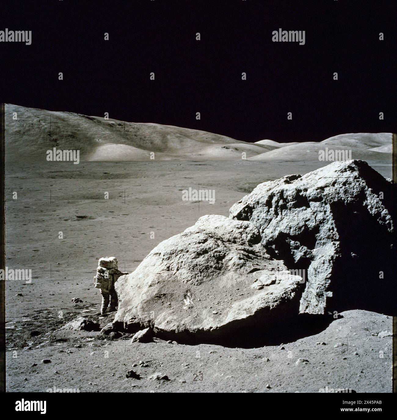 L'astronauta Harrison H. Schmitt si trova accanto a un enorme masso lunare diviso sulla luna durante il terzo Apollo 17 1972 Foto Stock