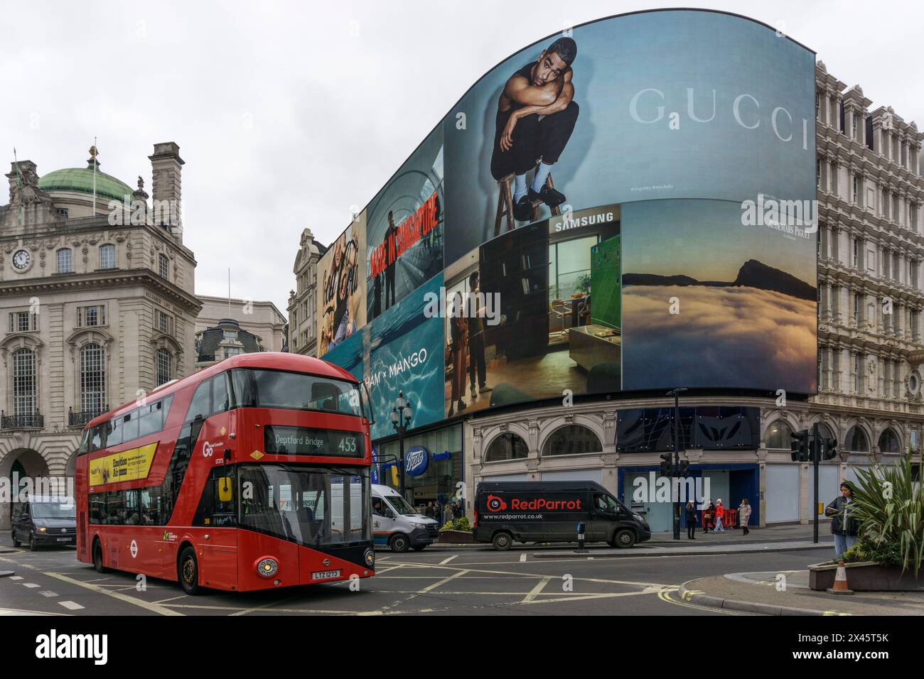 L'autobus rosso di Londra passa davanti a giganteschi video pubblicitari al Piccadilly Circus. Foto Stock