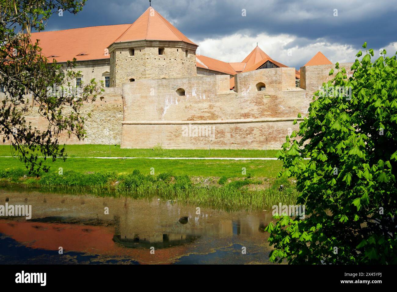 Paesaggio dalla città di Fagaras in Transilvania, Romania: Un fossato con acqua e un'antica fortezza di fronte ad esso Foto Stock