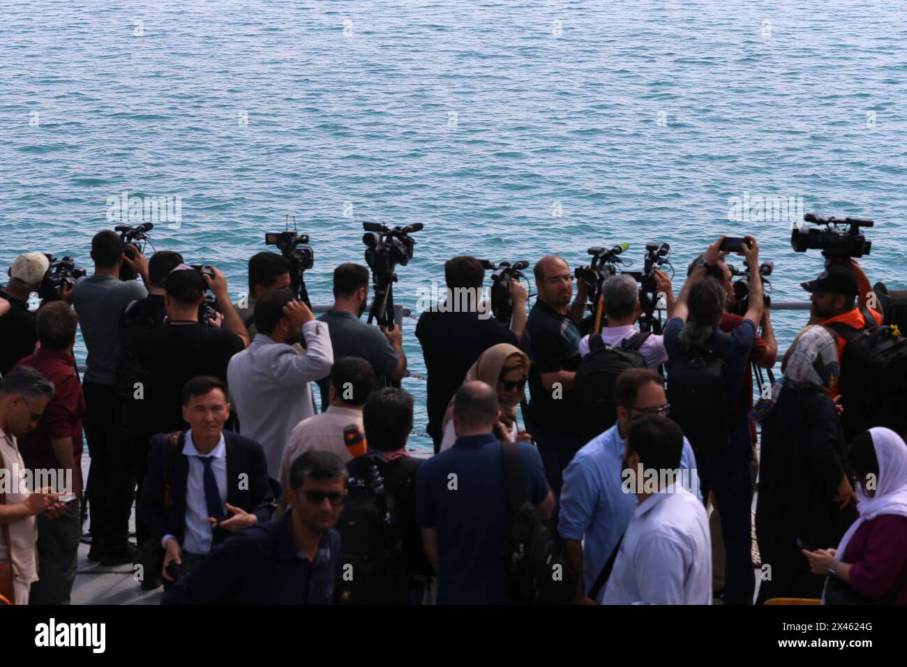 29 aprile 2024, Golfo Persico, Bushehr, Iran: video giornalisti stranieri che filmano il Golfo Persico sono a bordo di una nave da guerra IRIS 112 Shahid (martire) Salimi del corpo delle guardie rivoluzionarie islamiche (IRGC) nel Golfo Persico durante la parata marina dell'IRGC per commemorare la giornata nazionale del Golfo Persico vicino alla centrale nucleare di Bushehr nella città portuale di Bushehr, provincia di Bushehr, Iran meridionale. L'Iran celebra l'anniversario della liberazione del sud del paese dall'occupazione portoghese nel 1622 come "giornata nazionale del Golfo Persico" a Bushehr il 29 aprile 2024. La data coincide con l'anniversario Foto Stock
