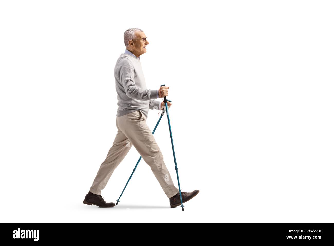 Immagine a tutta lunghezza di un uomo anziano che cammina con pali isolati su sfondo bianco Foto Stock