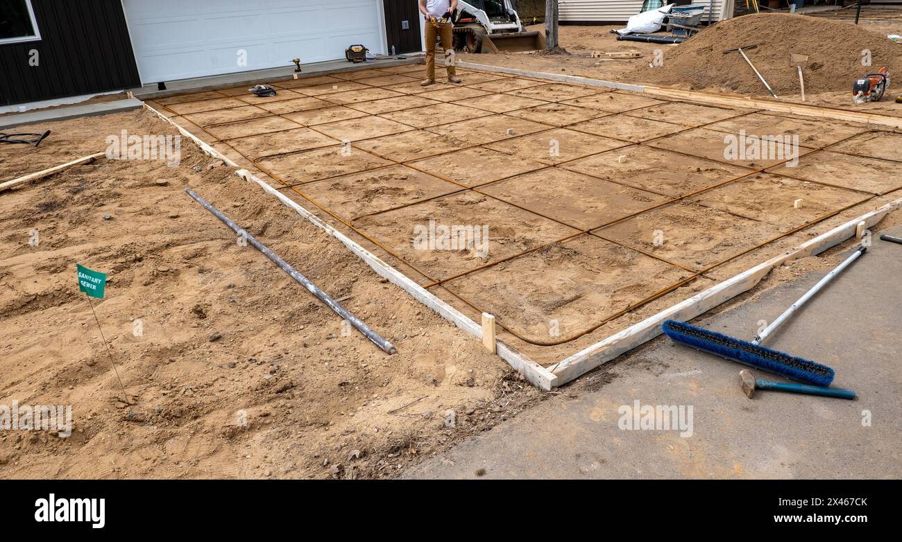 Telaio in legno e barre di rinforzo in acciaio o tondini utilizzati per la preparazione di vialetti in calcestruzzo in cantiere. Foto Stock