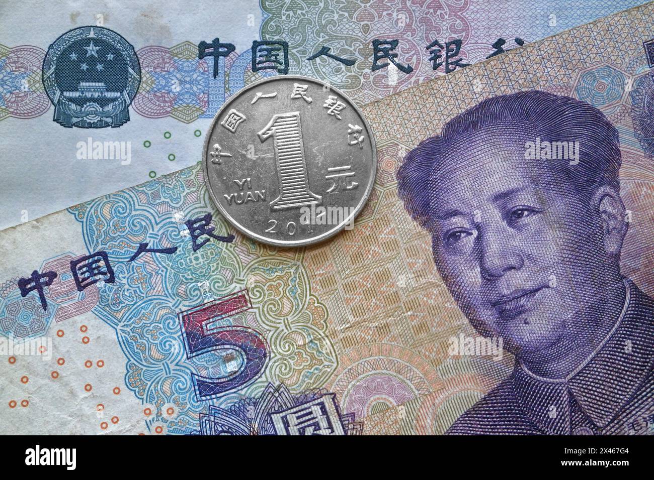 Una moneta da 1 yuan sopra una banconota da 5 yuan e una banconota da 10 yuan. Foto Stock