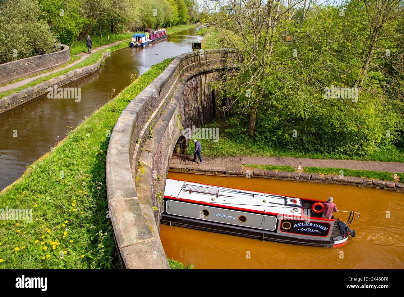 Canal narrowboat sulla linea principale di Trent e Mersey passando sotto il ramo Hall Green della Trent and Mersey presso il personale di Poole's Aqueduct Kidsgrove Foto Stock