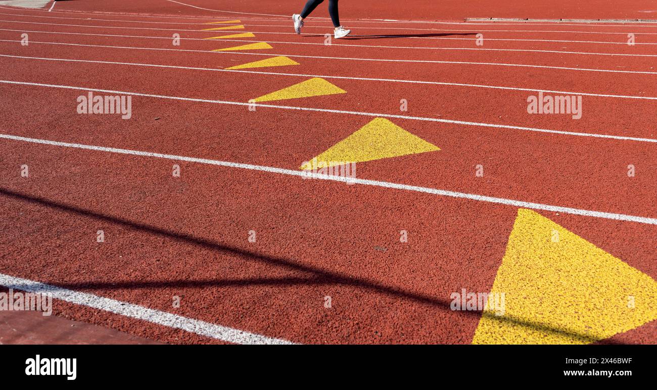 Vista parziale di un atleta che si allena su una corsia della pista di atletica presso un centro sportivo all'aperto di Parigi in una giornata di sole Foto Stock