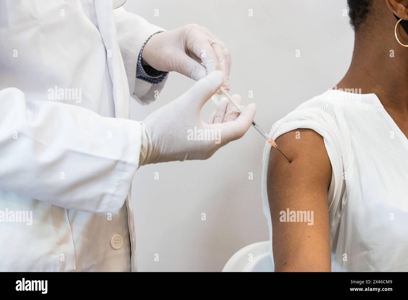 Primo piano della medica di coltura che fa l'iniezione per la paziente femmina nera Foto Stock