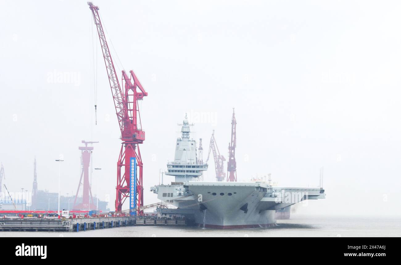 (240501) -- SHANGHAI, 1° maggio 2024 (Xinhua) -- la terza portaerei cinese, la Fujian, ormeggia nella zona orientale di Shanghai il 30 aprile 2024. La terza portaerei cinese, la Fujian, è partita per le prime prove in mare mercoledì mattina. La nave ha lasciato Shanghai intorno alle 8 del mattino. Le prove in mare testeranno principalmente l'affidabilità e la stabilità della propulsione e dei sistemi elettrici della portaerei. Dal suo lancio nel giugno 2022, il Fujian ha completato le prove di ormeggio, i lavori di allestimento e le regolazioni delle attrezzature. Ha soddisfatto i requisiti tecnici per le prove in mare. (Xinhua/li Yun) Foto Stock